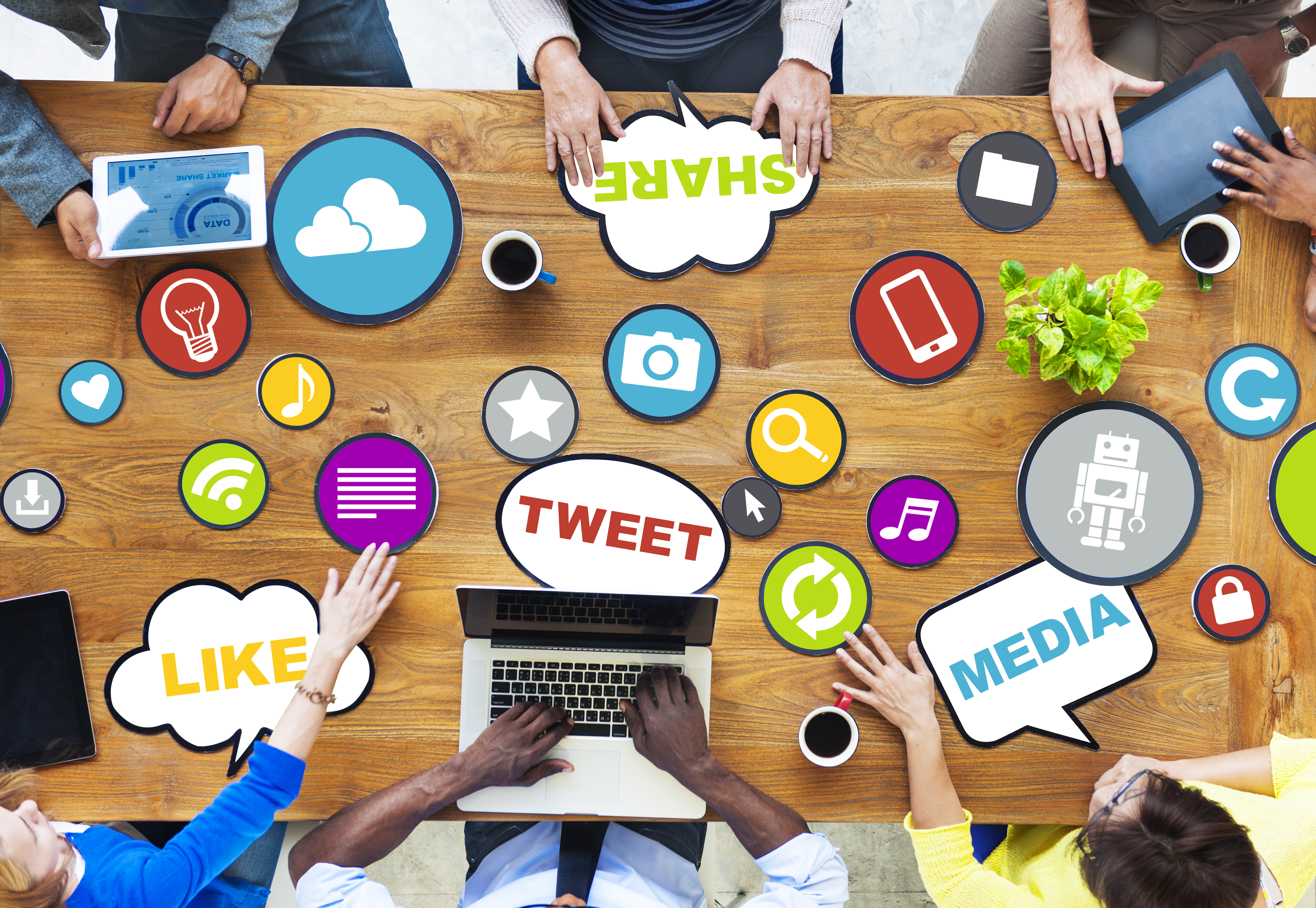 employees around a desk with laptops and animations of social media icons